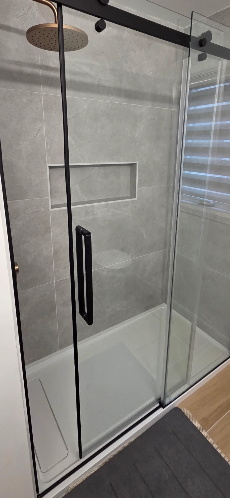 Completed grey tile shower with sliding glass door
